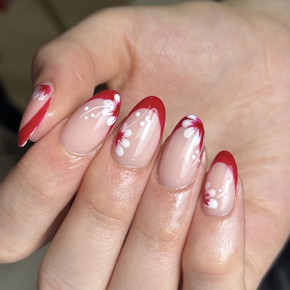 Rode French tips met witte bloemetjes op amandelvormige nagels