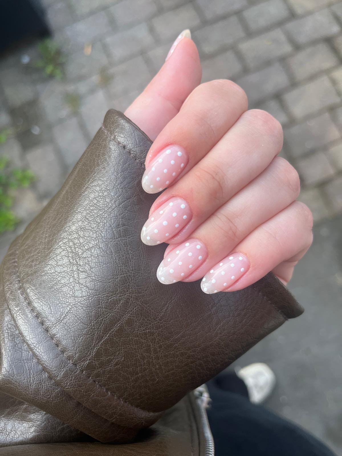 Witte stippen op roze, amandelvormige nagels